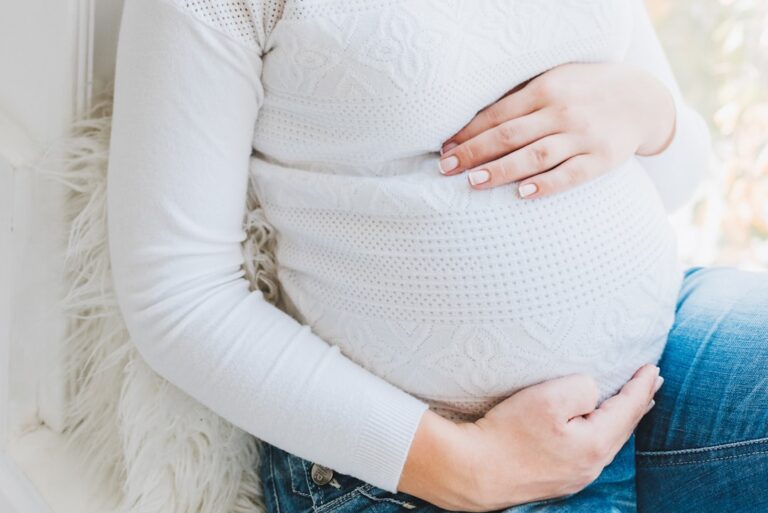 Pregnant woman resting her hands on her belly