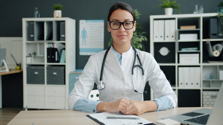 Female clinician seated at a desk in a clinic office
