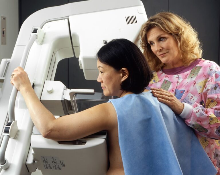 Woman positioned for a mammogram as part of a well-women exam